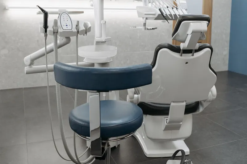 A clean, modern dental treatment room with the chair ready for the next patient